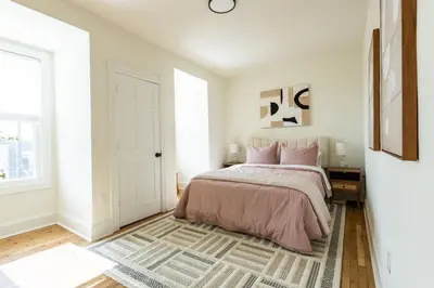 a white bedroom with a bed and a rug at The Lancastrian House Downtown in Lancaster