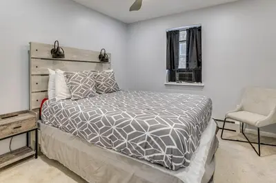 a bedroom with a bed and a chair at 7 Mi to Slopes Family Getaway in Stroudsburg in Stroudsburg
