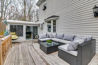 a patio with a couch and a table on a deck at 7 Mi to Slopes Family Getaway in Stroudsburg in Stroudsburg