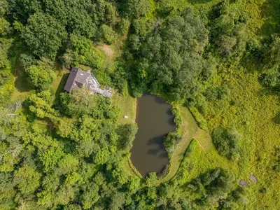 an aerial view of a house and a pond at Bootleg Hollow in Andes