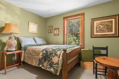 a bedroom with a bed and a table and a window at Bootleg Hollow in Andes