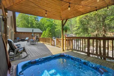 a patio with a swimming pool on a deck at Relaxing Pocono Stay Near Lake with Hot Tub & BBQ in Blakeslee