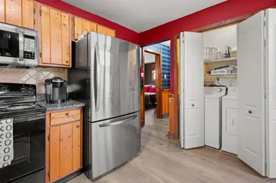 a kitchen with a stainless steel refrigerator and wooden cabinets at Relaxing Pocono Stay Near Lake with Hot Tub & BBQ in Blakeslee