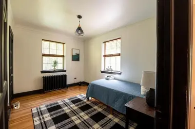 a bedroom with a blue bed and two windows at The Minimalist Retreat in Conestoga