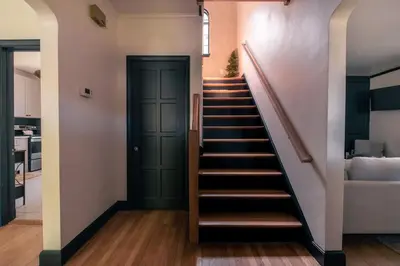 a staircase in a house with a green door at The Minimalist Retreat in Conestoga