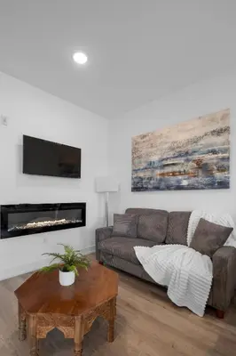a living room with a couch and a table at Bright Studio Haven - Pool, Gym & Balcony Views in Philadelphia