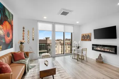 a living room with a couch and a tv at Sleek 1BR Hideaway - Gym, Pool Balcony in Philadelphia