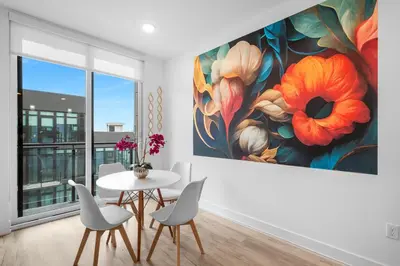 a dining room with a large flower painting on the wall at Bright 1BR Haven - Balcony Skyline Views in Philadelphia