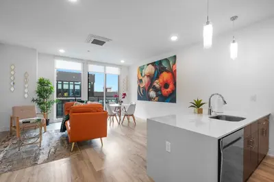 a kitchen and living room with a table and chairs at Bright 1BR Haven - Balcony Skyline Views in Philadelphia