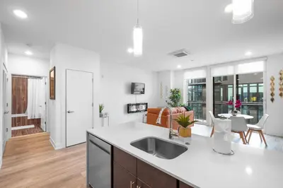 a kitchen with a sink and a living room at Bright 1BR Haven - Balcony Skyline Views in Philadelphia