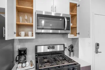 a kitchen with a microwave and a stove top oven at Bright 1BR Haven - Balcony Skyline Views in Philadelphia