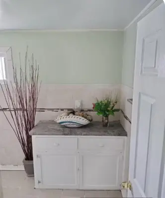 a white cabinet with a vase on top of it at Private Room - Shared Bathroom in Perth Amboy