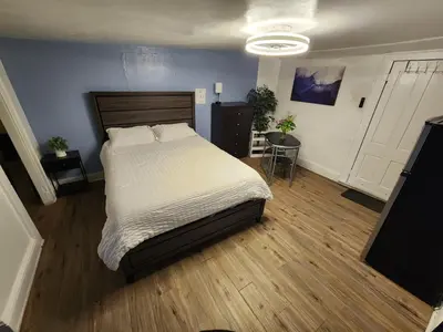 a bedroom with a large bed and a television at Private Room - Shared Bathroom in Perth Amboy
