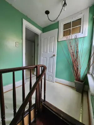 a stairway with green walls and a white door at Private Room - Shared Bathroom in Perth Amboy