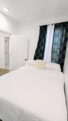 a bedroom with a large white bed with white sheets at 3bedroom 2 bath minutes away from Temple, Philly museum, Philly zoo , center city in Philadelphia