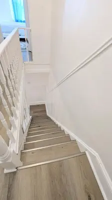 a stairway with white stairs and a wooden floor at 3bedroom 2 bath minutes away from Temple, Philly museum, Philly zoo , center city in Philadelphia