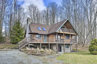 a large wooden house with a large deck at Family Cabin and Suite Near Elk Mountain Ski Slopes in Pleasant Mount