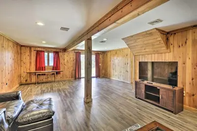 a living room with a couch and a large television at Log Cabin and Suite, Friendly Retreat Close to Skiing in Pleasant Mount