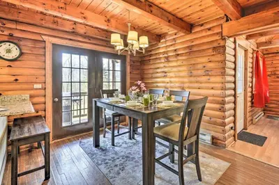 a dining room with a table and chairs in a cabin at Log Cabin and Suite, Friendly Retreat Close to Skiing in Pleasant Mount