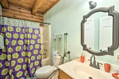 a bathroom with a toilet and a shower curtain at Log Cabin and Suite, Friendly Retreat Close to Skiing in Pleasant Mount