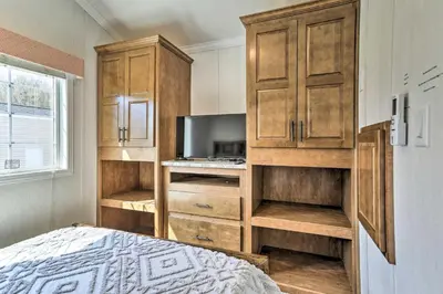 a bedroom with a bed and a tv and wooden cabinets at Family Suites Close to Elk Mountain Ski Resort in Pleasant Mount