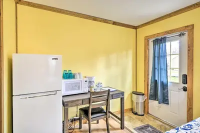 a kitchen with a table with a microwave and a refrigerator at Family Cabin and Suites Close to Ski Adventures in Pleasant Mount