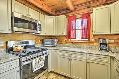 a kitchen with white cabinets and a stove top oven at Family Cabin and Suites Close to Ski Adventures in Pleasant Mount