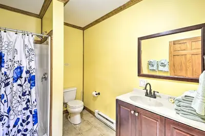 a bathroom with a sink and a toilet and a mirror at Family Cabin and Suites Close to Ski Adventures in Pleasant Mount