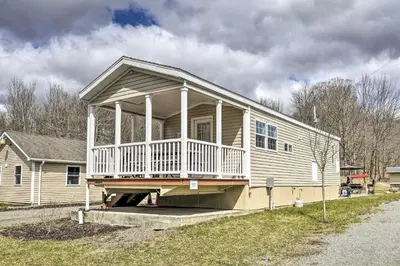 a house with a large porch on the side of it at Tranquil Trails Cabin & Suites Near Ski Area in Pleasant Mount