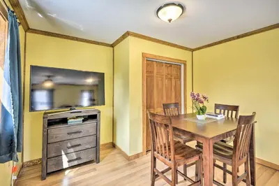 a dining room with a table and a tv at Tranquil Trails Cabin & Suites Near Ski Area in Pleasant Mount