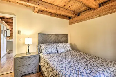a bedroom with a bed and a lamp and wooden ceilings at Log Cabin and Cottage Near Elk Mountain Ski Slopes in Pleasant Mount