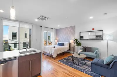 a kitchen and living room with a bed in a room at Stylish Studio - Pool, Gym & Balcony Bliss in Philadelphia