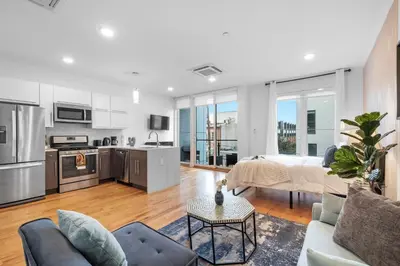 a kitchen and living room with a couch and a table at Stylish Studio - Pool, Gym & Balcony Bliss in Philadelphia