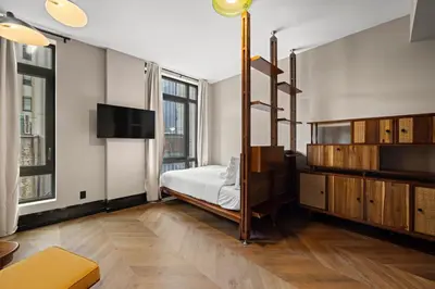 a bedroom with a bed and a tv in it at Freeman 401 by Rove Travel - Studio w Shared Amenities in New York