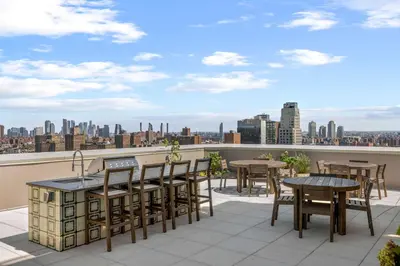 a balcony with tables and chairs and a view of the city at Freeman 401 by Rove Travel - Studio w Shared Amenities in New York