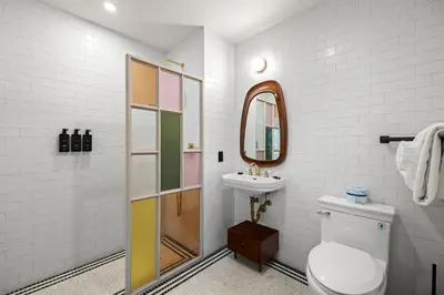 a bathroom with a toilet and a sink and a mirror at Freeman 401 by Rove Travel - Studio w Shared Amenities in New York