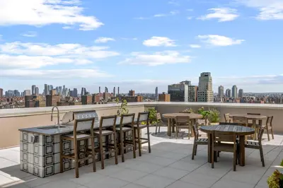 a balcony with tables and chairs and a view of the city at Freeman 601 by Rove Studio with Shared Amenities in New York