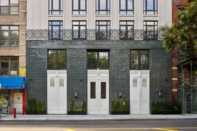 a brick building with white doors on a street at Freeman 601 by Rove Studio with Shared Amenities in New York