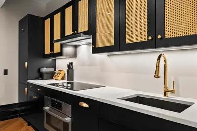 a kitchen with black cabinets and a sink at Freeman 601 by Rove Studio with Shared Amenities in New York