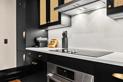 a kitchen with black cabinets and white counter tops at Freeman 601 by Rove Studio with Shared Amenities in New York