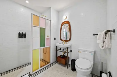 a bathroom with a toilet and a sink and a mirror at Freeman 701 by Rove Travel - Studio with Shared Amenities in New York