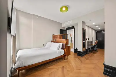 a bedroom with a bed and a tv in a room at Freeman 801 by Rove Travel - Studio with Shared Amenities in New York