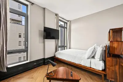 a bedroom with a bed and a large window at Freeman 1001 by Rove Travel - Studio with Shared Amenities in New York