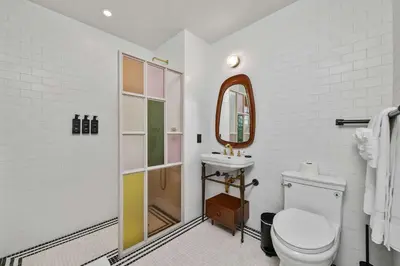 a bathroom with a toilet and a sink and a mirror at Freeman 1001 by Rove Travel - Studio with Shared Amenities in New York