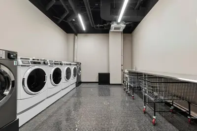 a laundry room with three washing machines in it at Freeman 1001 by Rove Travel - Studio with Shared Amenities in New York
