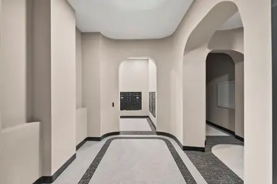 a hallway of a building with white walls and a carpet at Freeman 1101 by Rove Travel - Studio with Shared Amenities in New York