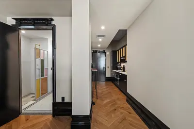 a hallway with white walls and a mirror at Freeman 1101 by Rove Travel - Studio with Shared Amenities in New York
