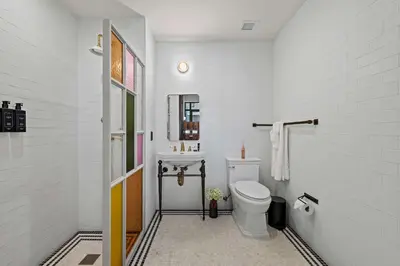 a white bathroom with a toilet and a sink at Freeman 1201 by Rove Travel - Studio with Shared Amenities in New York