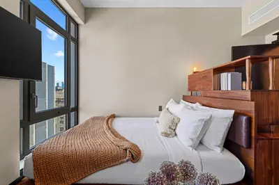 a bedroom with a bed with a large window at Freeman 1201 by Rove Travel - Studio with Shared Amenities in New York