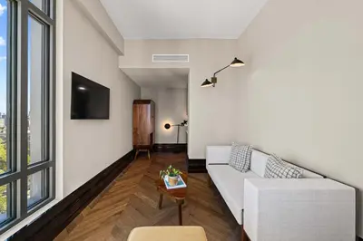 a living room with a white couch and a tv at Freeman 203 by Rove Travel -1BR Condo with Shared Amenities in New York